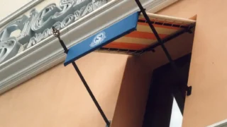 日よけ用の固定式テントをホテルの小窓に施工